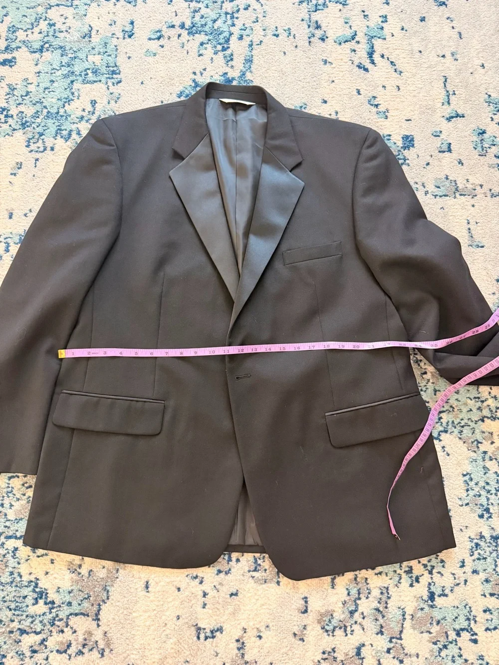 black Versini tuxedo jacket with a single-button closure and satin notch lapels.